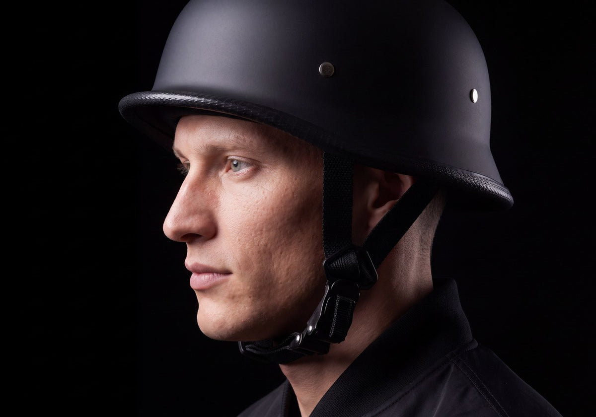Rider in profile wearing a matte German-style half helmet