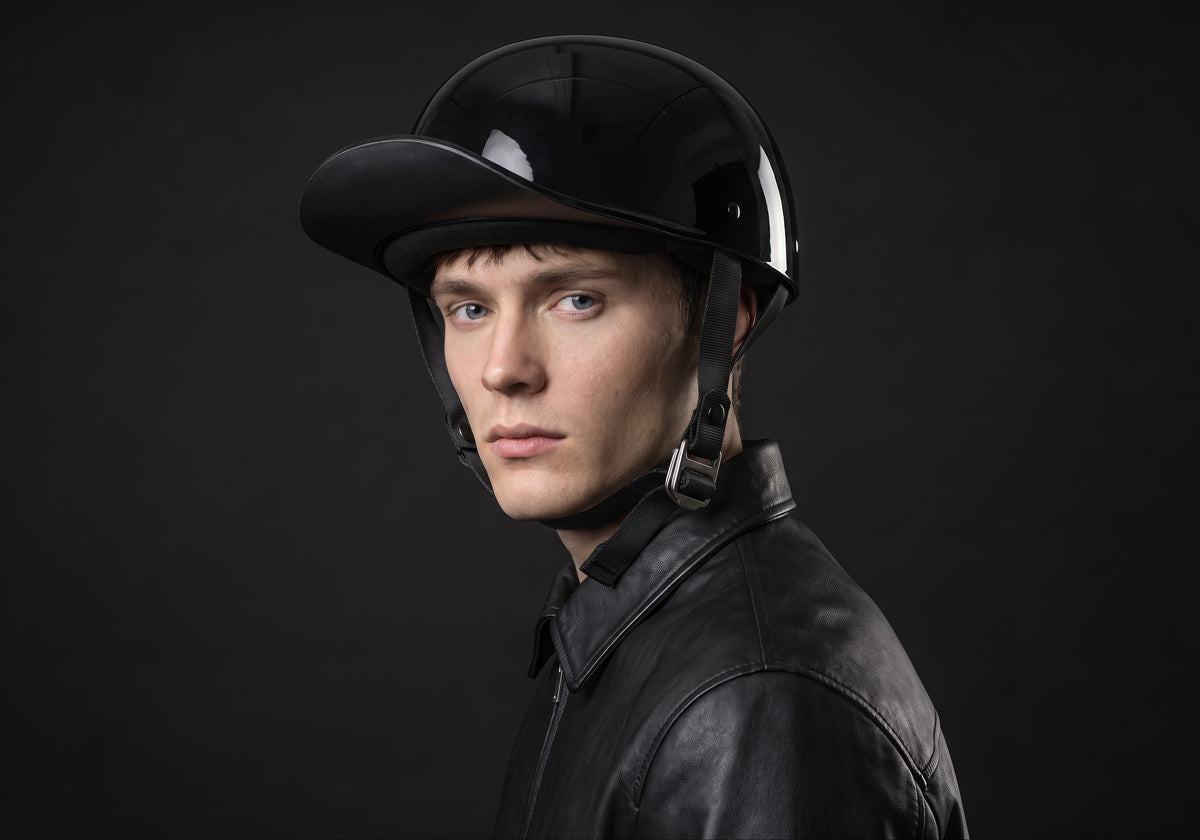 Velmurax baseball cap style helmet in gloss black, worn by a rider, seen in a three-quarter front view on the dark studio set