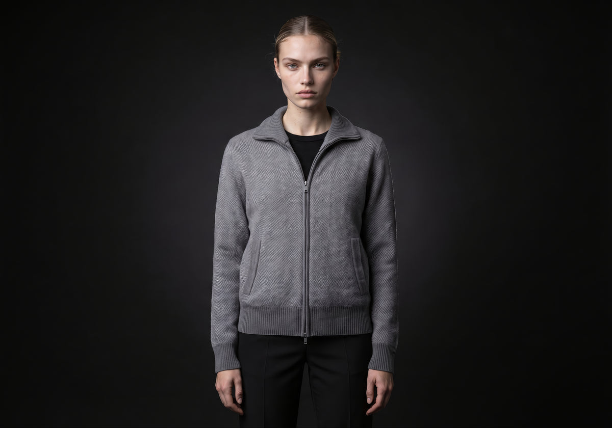Velmurax cashmere zip cardigan in gray, worn by the model in a front view on the dark studio set