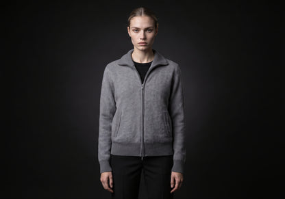 Velmurax cashmere zip cardigan in gray, worn by the model in a front view on the dark studio set
