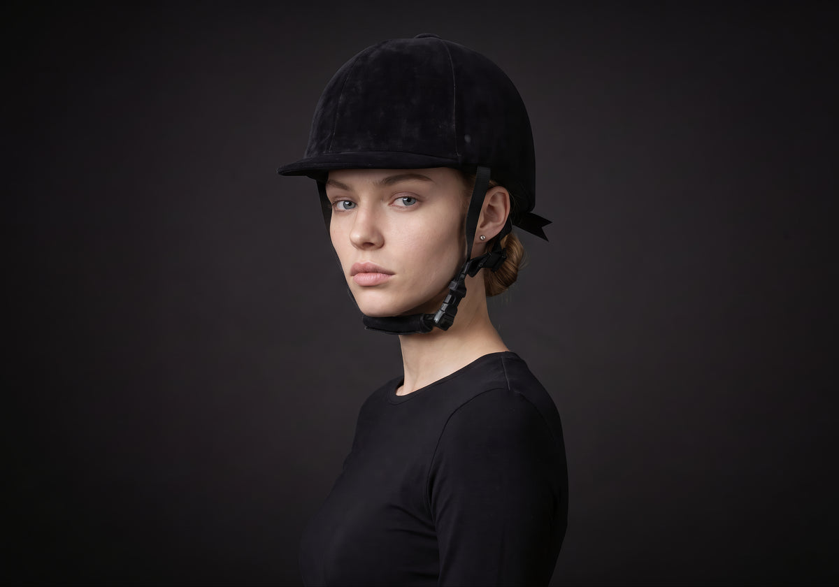 Velmurax classic velvet riding helmet in black velvet, worn by a rider, seen in a three-quarter front view on the dark studio set