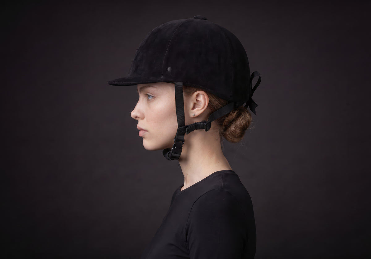 Velmurax classic velvet riding helmet in black velvet, in side profile on a rider