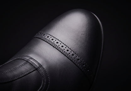 Velmurax cowhide paddock boots in black, the stitched toe cap up close, worn