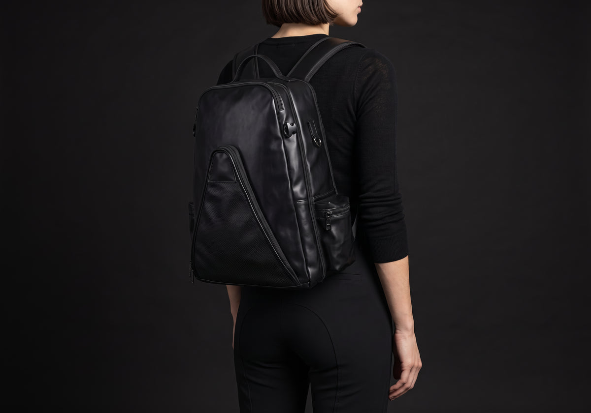 Velmurax equestrian backpack in black, carried on a rider's back with both straps on