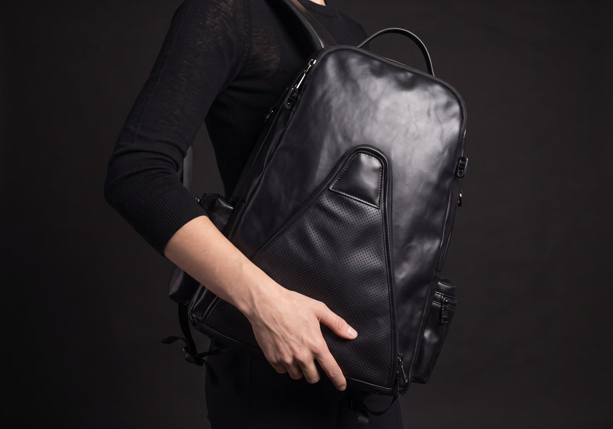 Velmurax equestrian backpack in black, held in one hand at the rider's side
