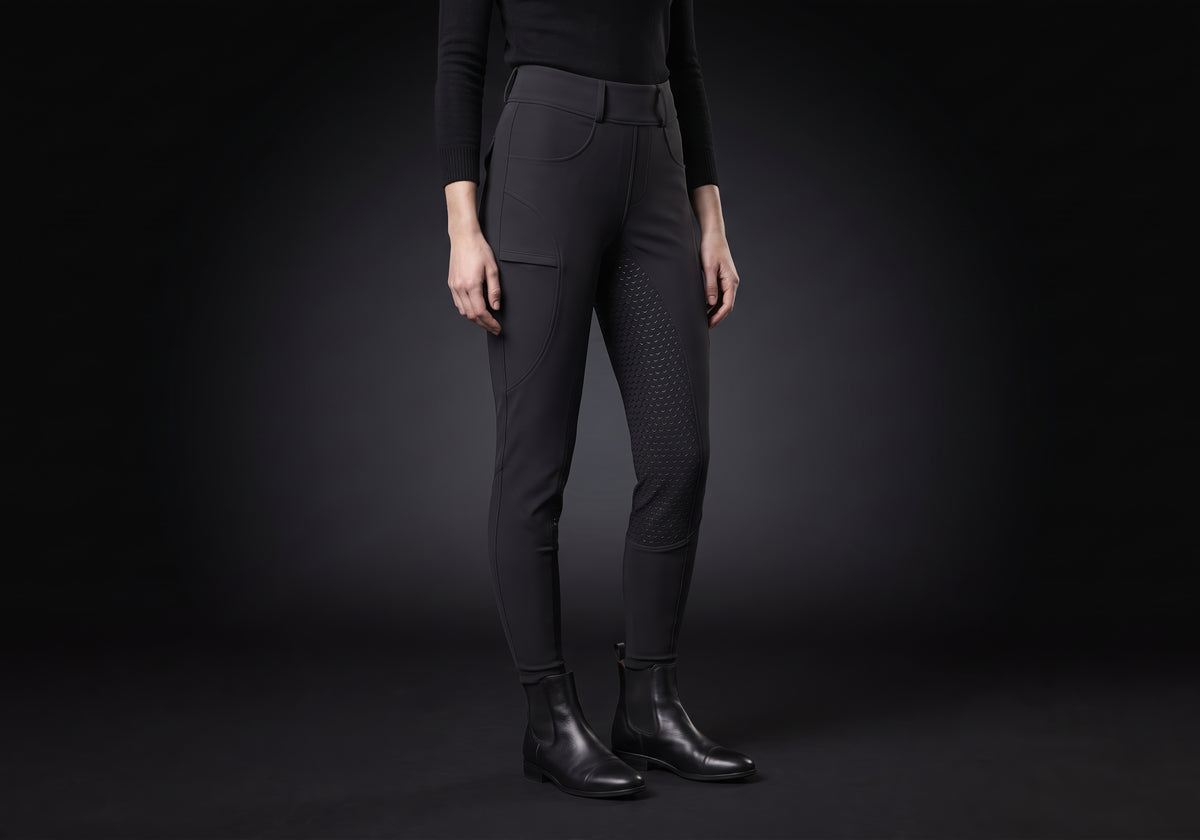 Velmurax fleece-lined winter riding pants in black, worn by a rider, seen from the ribcage down on the dark studio set
