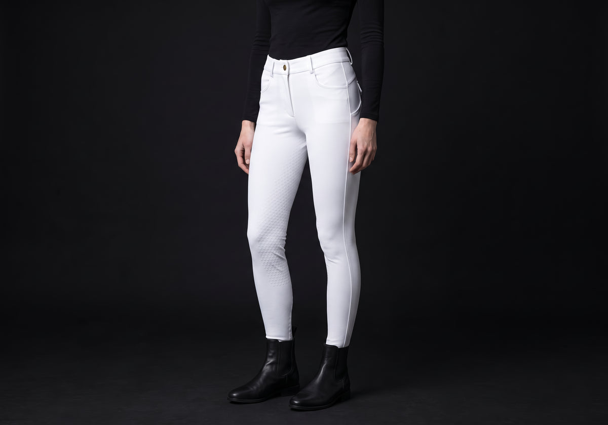 Velmurax full-seat riding breeches in white, worn by a rider, seen from the ribcage down on the dark studio set