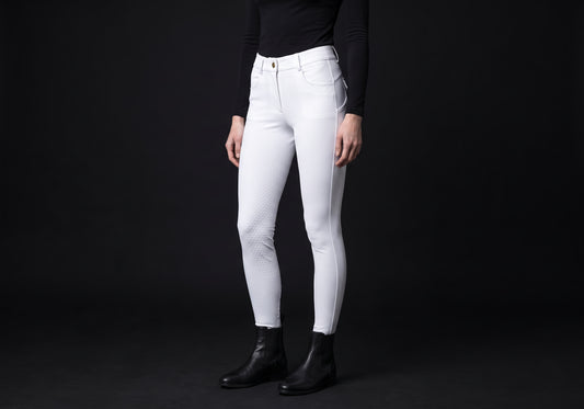 Velmurax full-seat riding breeches in white, worn by a rider, seen from the ribcage down on the dark studio set