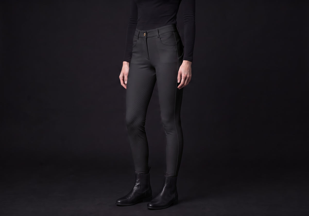 Velmurax full-seat riding breeches in black, worn by a rider, seen from the ribcage down on the dark studio set