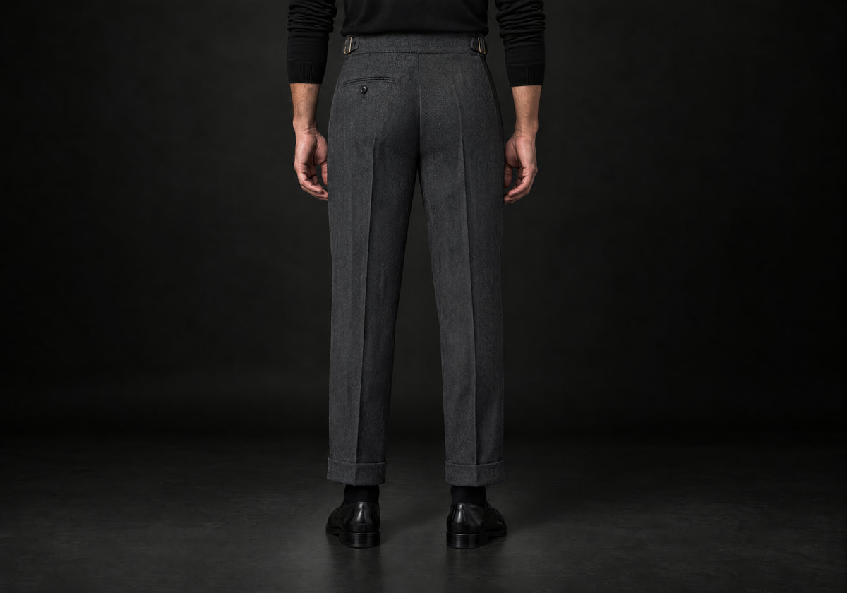 Velmurax Herringbone Wool-Blend Pants in dark gray with a button back pocket and side buckle tabs, back view on a model