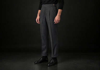 Velmurax Herringbone Wool-Blend Pants in dark gray with cuffed hems and a side buckle tab, three-quarter view on a model