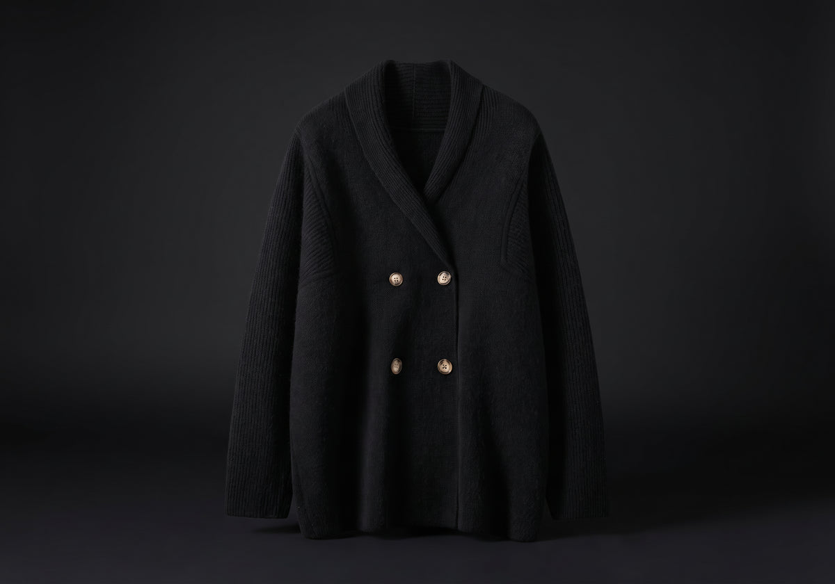 Velmurax knit cashmere coat in black, on its own on the dark studio set