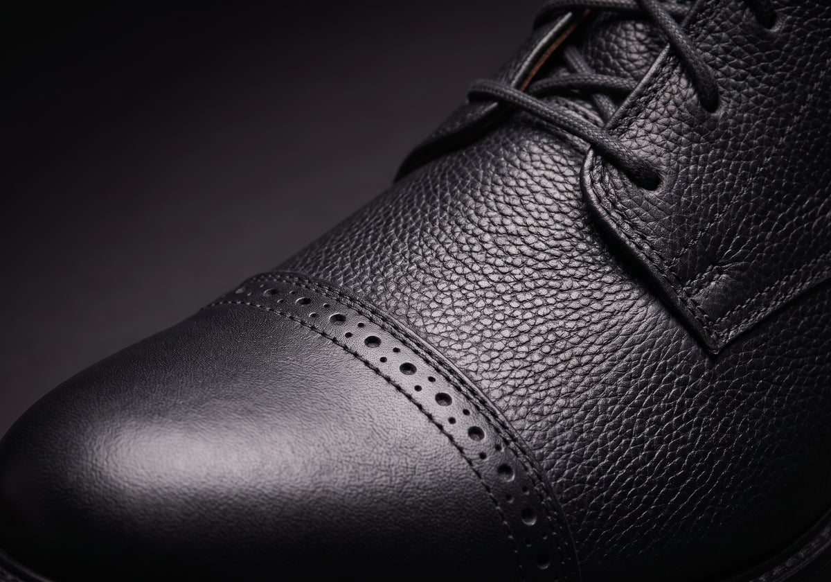 Velmurax leather paddock boots in black, the brogue toe cap and grained leather up close, worn