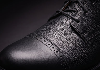 Velmurax leather paddock boots in black, the brogue toe cap and grained leather up close, worn