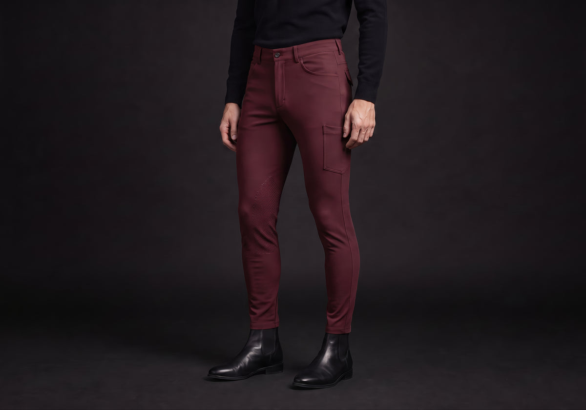 Velmurax men's riding breeches in burgundy, worn by a rider, seen from the ribcage down on the dark studio set
