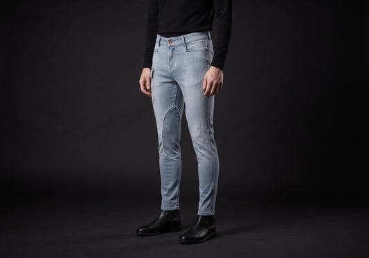 Velmurax men's stretch riding jodhpurs in light gray, worn by a rider, seen from the ribcage down on the dark studio set