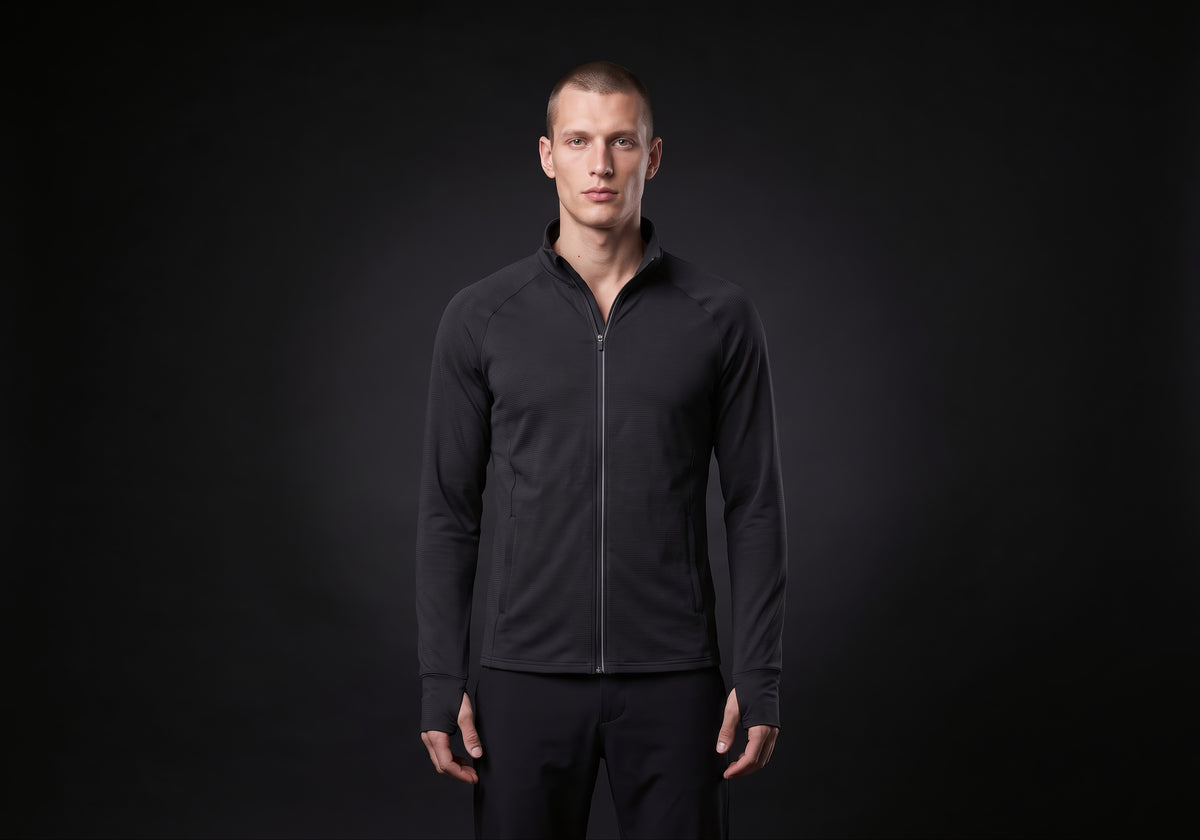 Velmurax men's stretch track jacket in black, worn by the model in a front view on the dark studio set