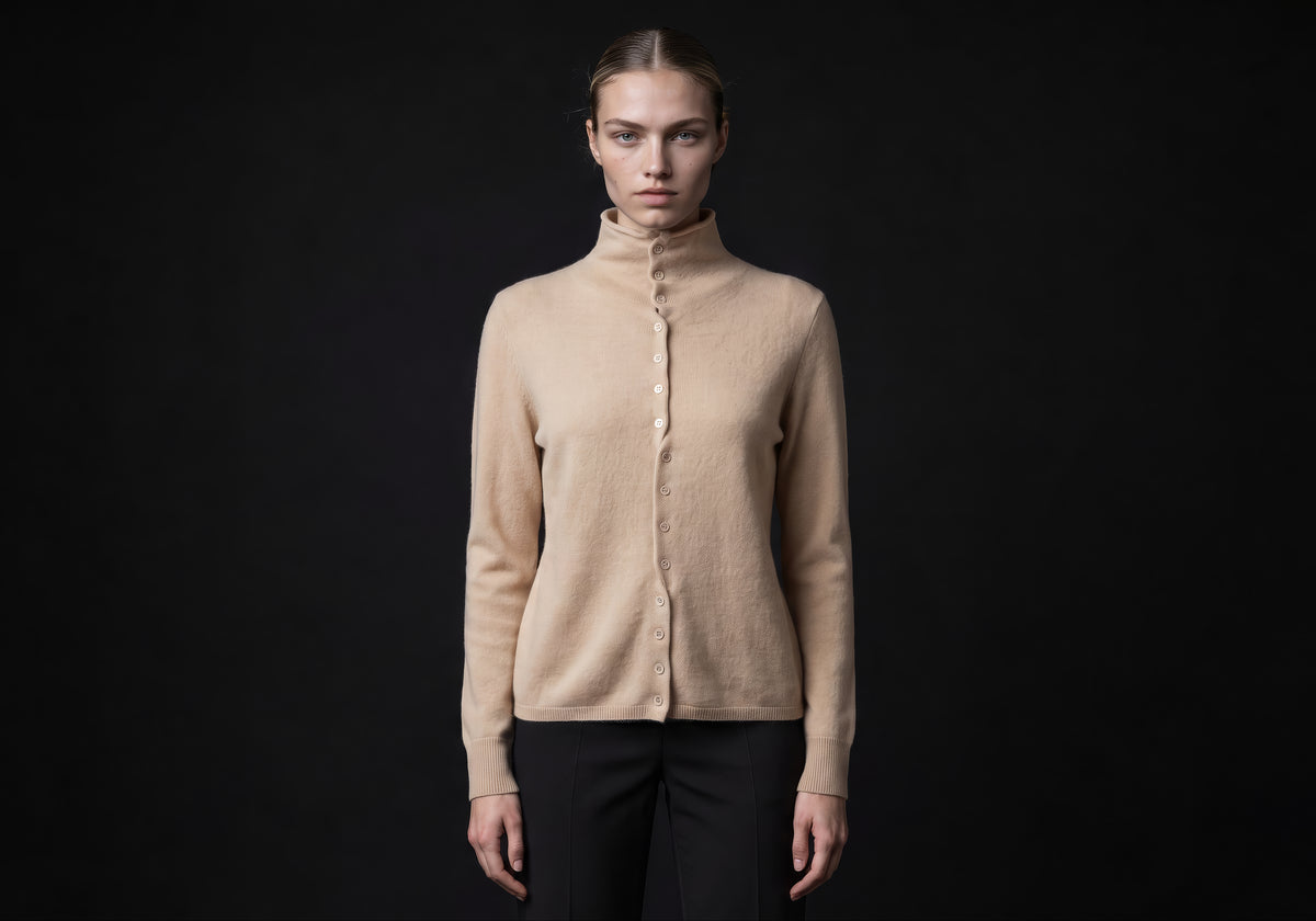 Velmurax mock neck cashmere cardigan in beige, worn by the model in a front view on the dark studio set