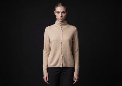 Velmurax mock neck cashmere cardigan in beige, worn by the model in a front view on the dark studio set