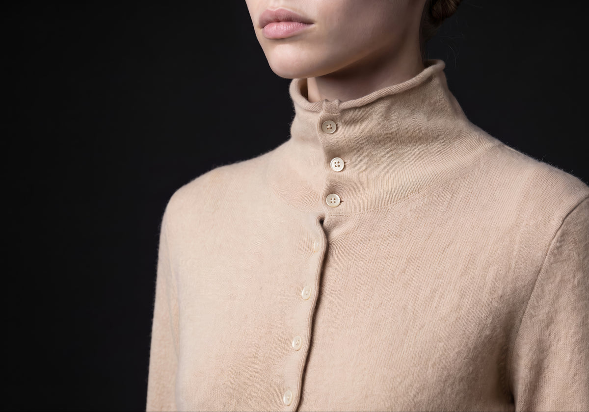 Velmurax mock neck cashmere cardigan in beige, in a close detail shot on the model