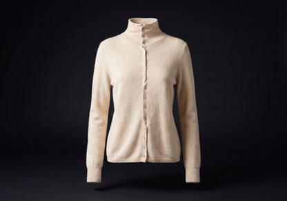 Velmurax mock neck cashmere cardigan in ivory, on its own on the dark studio set