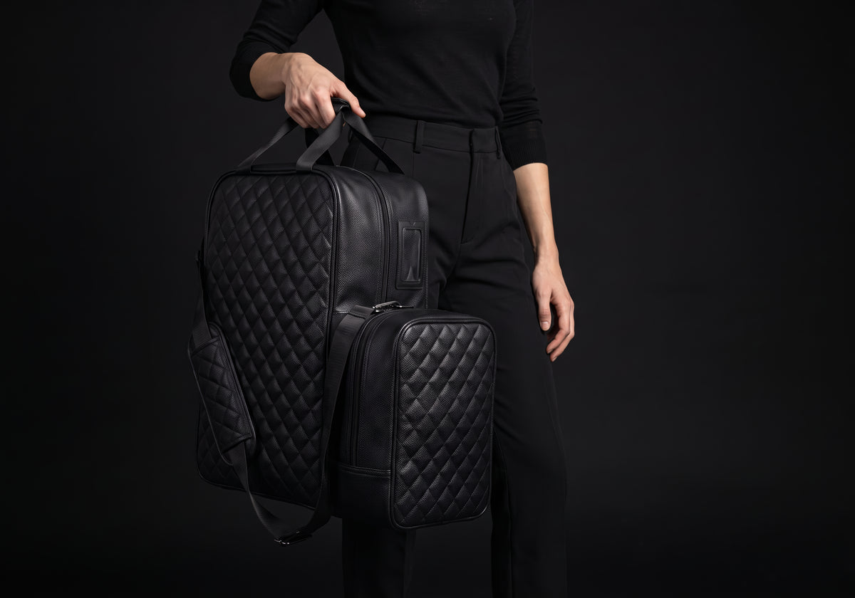 Velmurax quilted boot and helmet bag in black, carried by its two top handles