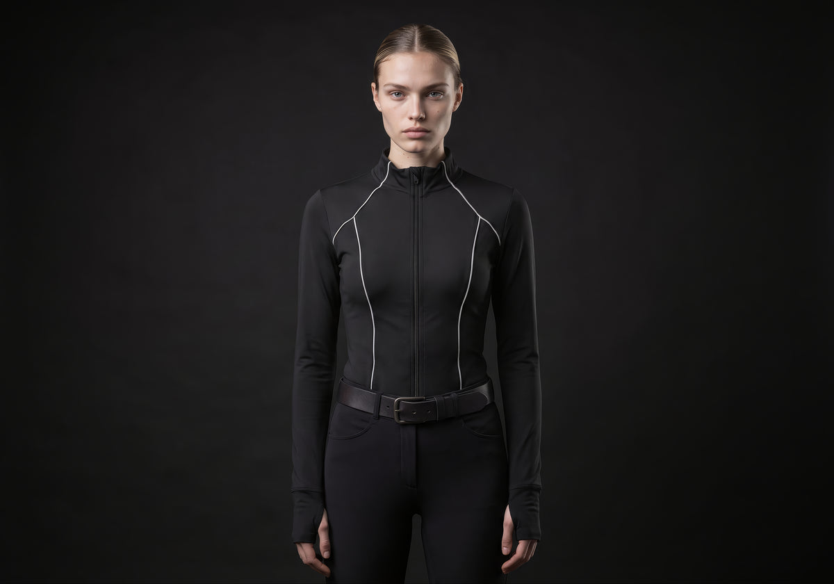 Velmurax women's long-sleeve riding top in black, worn by the model in a front view on the dark studio set