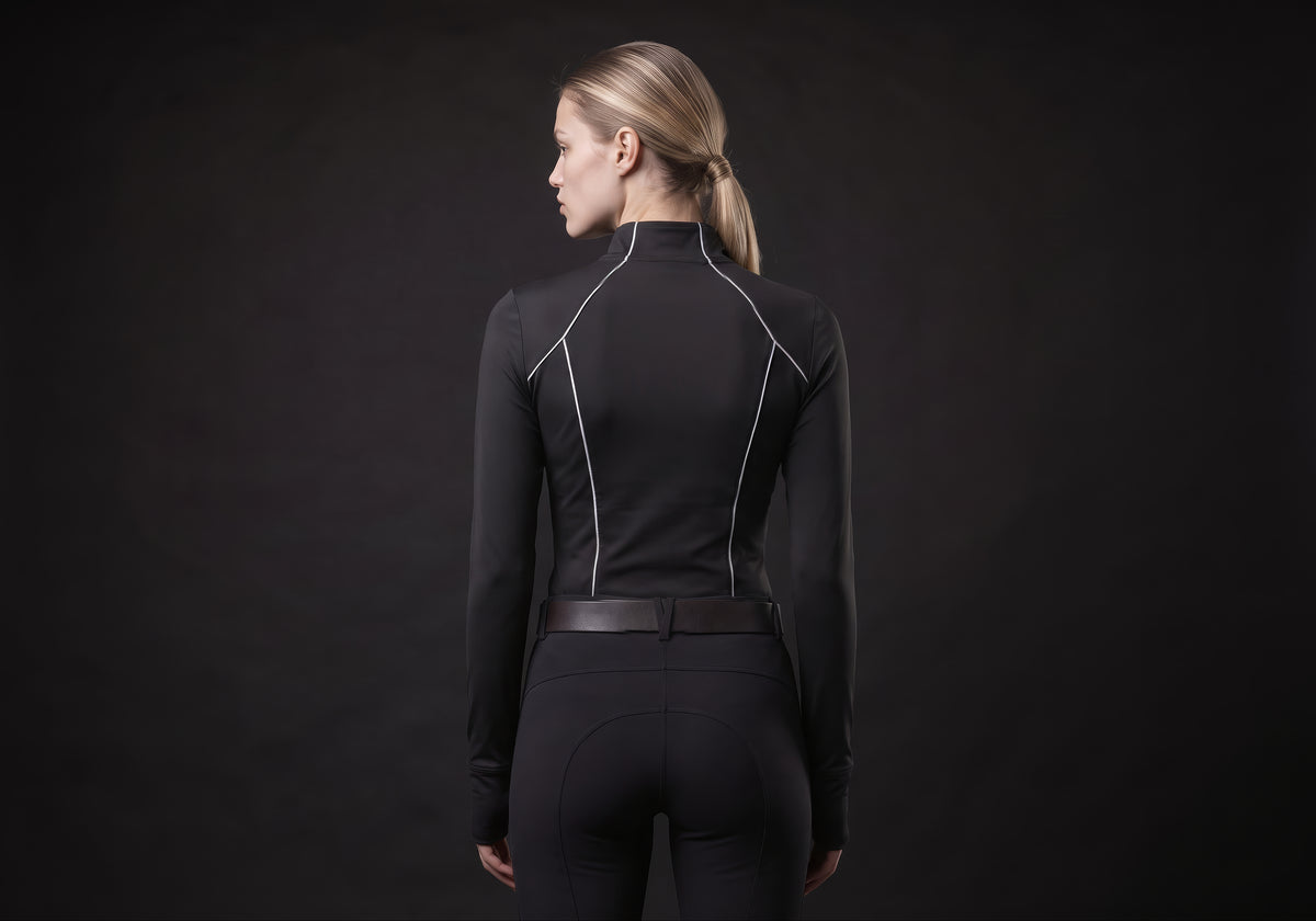Velmurax women's long-sleeve riding top in black, seen from the back on the model, showing the back of the garment