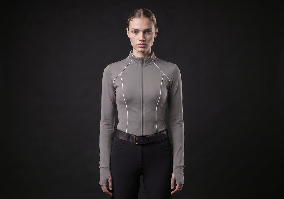 Velmurax women's long-sleeve riding top in gray, worn by the model in a front view on the dark studio set