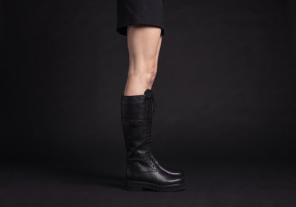 Velmurax women's lace-up knee-high boots in black, worn, in side profile