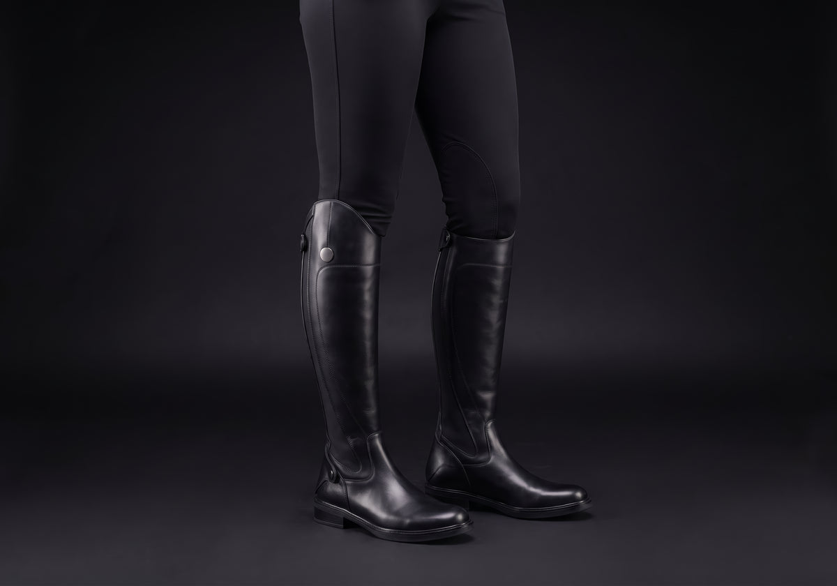 Velmurax women's long riding boots in black, worn by a rider with breeches tucked in
