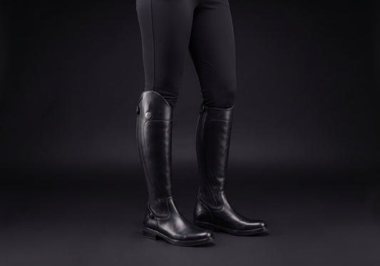 Velmurax women's long riding boots in black, worn by a rider with breeches tucked in
