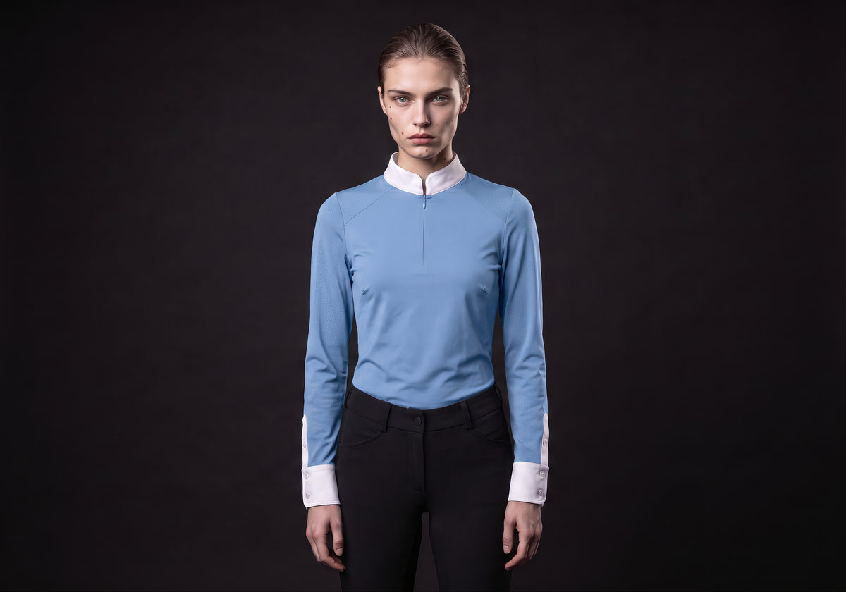 Velmurax women's show shirt in light blue, worn by the model in a front view on the dark studio set
