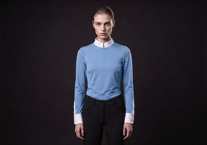 Velmurax women's show shirt in light blue, worn by the model in a front view on the dark studio set