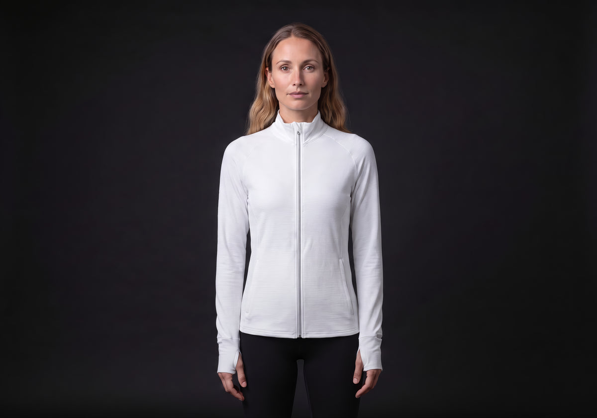 Velmurax women's stretch track jacket in white, worn by the model in a front view on the dark studio set