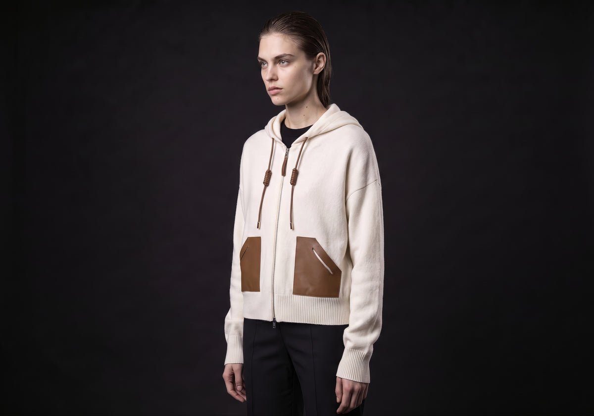 Velmurax wool cashmere zip hoodie in ivory, in a three-quarter view on the model on the studio set