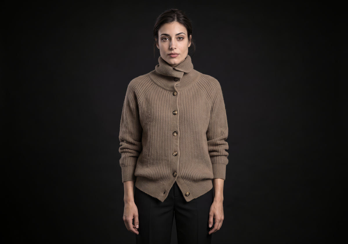 Velmurax wool turtleneck cardigan in taupe with the collar folded over, worn buttoned over black tailored trousers