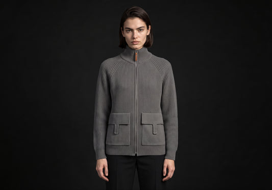 Velmurax wool zip cardigan in gray, worn by the model in a front view on the dark studio set